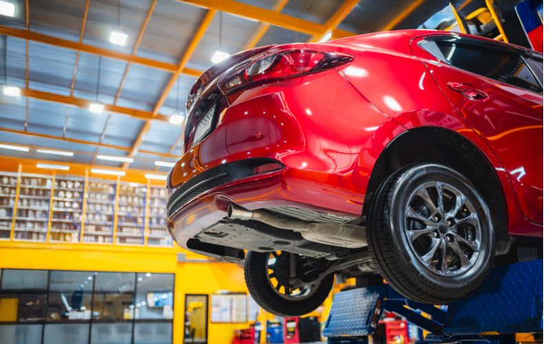 Voiture sur pont élévateur dans un atelier, contrôle de carrosserie.
